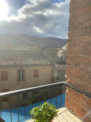 un balcon avec vue sur un immeuble dans l'établissement Gîte cévenol de caractère tout équipé, piscine, aire de jeu et jardin, à Meyrannes