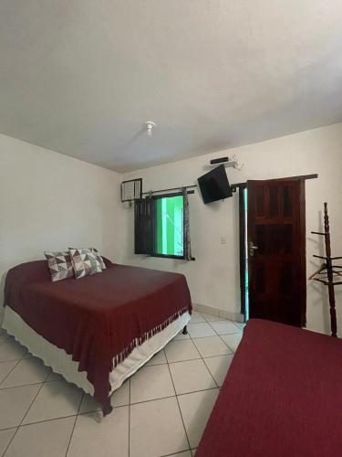 a bedroom with a bed and a flat screen tv at Pousada do Cacau in Arraial d'Ajuda