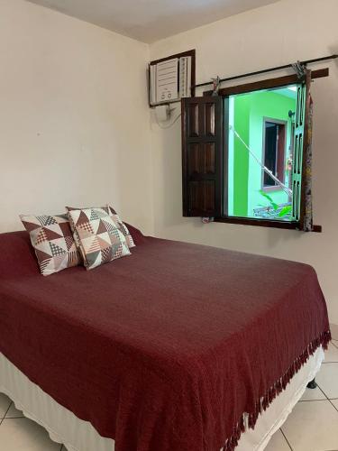 a bedroom with a bed and a window at Pousada do Cacau in Arraial d'Ajuda