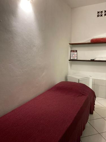 a bedroom with a bed with a red blanket at Pousada do Cacau in Arraial d'Ajuda