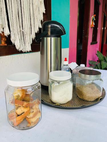 a table with two jars of food and a thermos at Pousada do Cacau in Arraial d'Ajuda