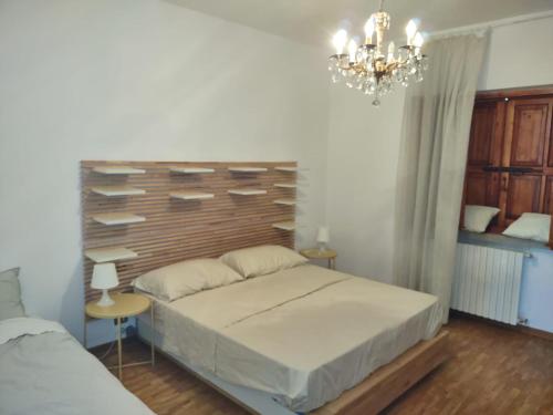 a bedroom with a bed and a chandelier at Villa Nonna Elisa in Pieve