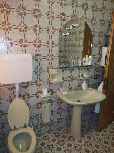 a bathroom with a toilet and a sink and a mirror at Villa Nonna Elisa in Pieve