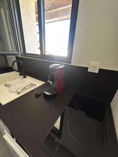 un bureau d'ordinateur noir avec une fenêtre dans une pièce dans l'établissement Villa mireval 6 personne, à Mireval