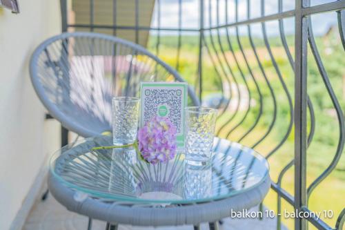 a blue table with glasses and a book and a flower at Remus House Apartments spokojny wypoczynek dla par, tylko pokoje 2-osobowe in Jastrzębia Góra