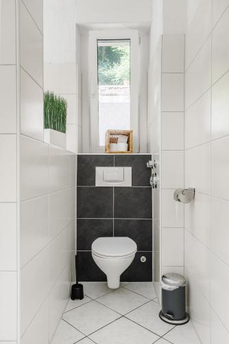 a white bathroom with a toilet and a window at Villa Plassenburg in Kulmbach