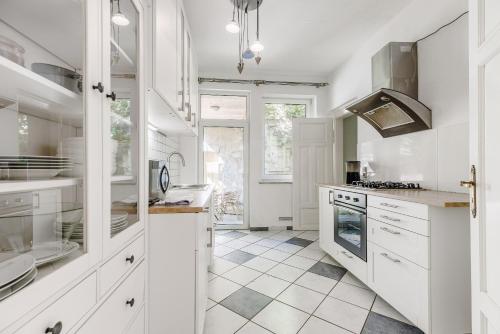 a kitchen with white cabinets and a stove top oven at Villa Plassenburg in Kulmbach
