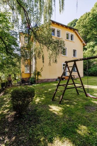 a swing in a yard in front of a house at Villa Plassenburg in Kulmbach