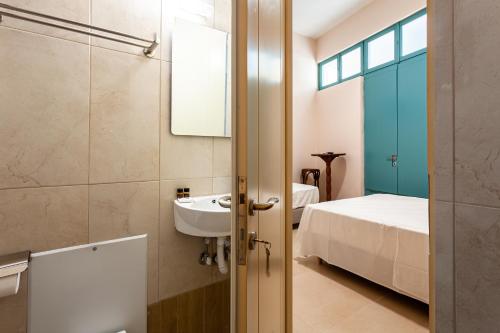 a bathroom with a sink and a bed at Στούντιο Στη Στοά Βαρβουτσή#9 in Kalamata