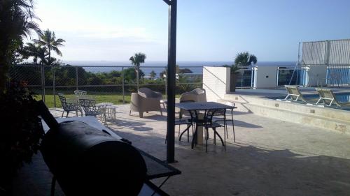 a patio with a table and chairs and the ocean at E&J Boutique Residences in Sosúa