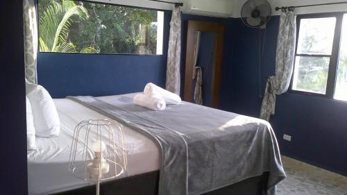a bedroom with a bed with a blue wall and a window at E&J Boutique Residences in Sosúa