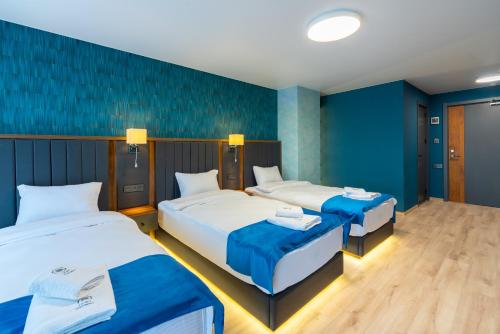 two beds in a room with blue walls at Gori Apartments in Gori