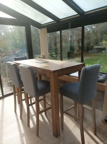 - une table et des chaises en bois dans une chambre avec fenêtre dans l'établissement Maison chaleureuse en bord de mer, à Moëlan-sur-Mer