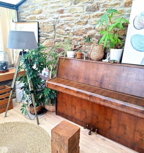 un banc en bois assis devant un mur en pierre dans l'établissement Maison chaleureuse en bord de mer, à Moëlan-sur-Mer