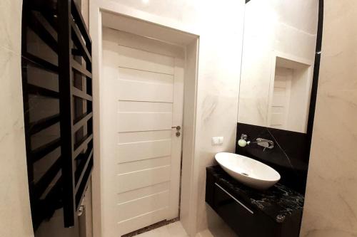 a bathroom with a white door and a sink at Luxury Apartment - Rakowicka R15 in Krakow