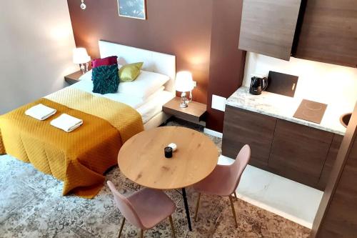 a bedroom with a bed and a table and chairs at Luxury Apartment - Rakowicka R15 in Krakow