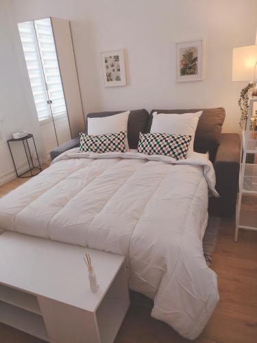 - un grand lit blanc avec des oreillers dans l'établissement Appartement proche de Paris Canal,Disney, Netflix, à Aulnay-sous-Bois