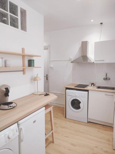 - une cuisine blanche avec un lave-linge et un évier dans l'établissement Appartement proche de Paris Canal,Disney, Netflix, à Aulnay-sous-Bois