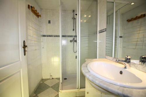 une salle de bain blanche avec un lavabo et une douche dans l'établissement Résidence Palafour - 1 séjour canapé lit, 1 cabine lit superposés - balcon vue lac MAE-3762, à Tignes