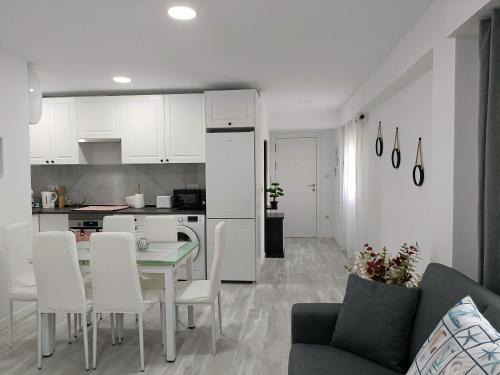 eine Küche und ein Wohnzimmer mit Tisch und Stühlen in der Unterkunft Mare de Deu, vivienda vacacional para familias y mayores de 25 años en el Grao de Gandia-Playa in Puerto de Gandía