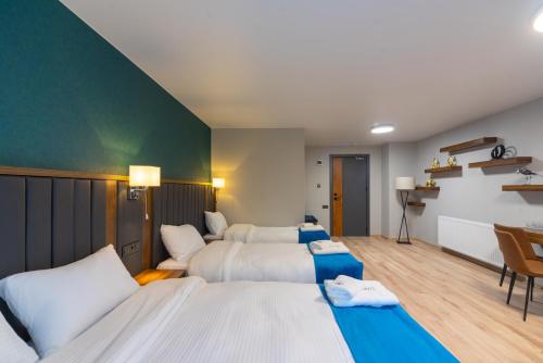 a bedroom with two beds and a green wall at Gori Apartments in Gori