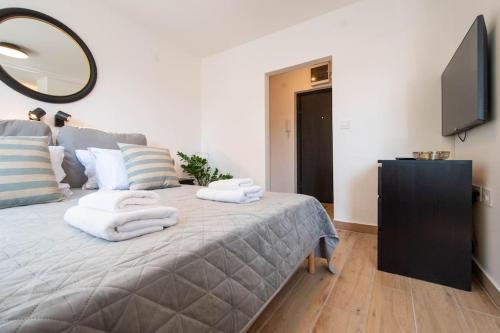 a bedroom with a bed with towels on it at Cozy Studio by Ivanka Design in Novi Sad