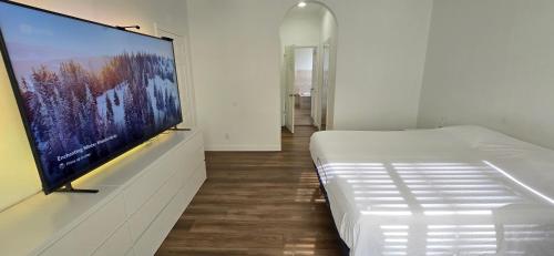 a bedroom with a large flat screen tv on a wall at Rent W Palm Beach in West Palm Beach