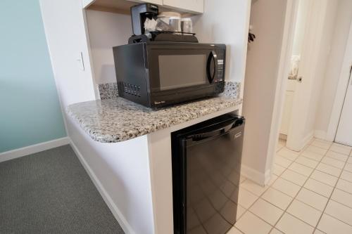 a kitchen with a microwave and a television on a counter at Oceanfront Litchfield Inn in Pawleys Island