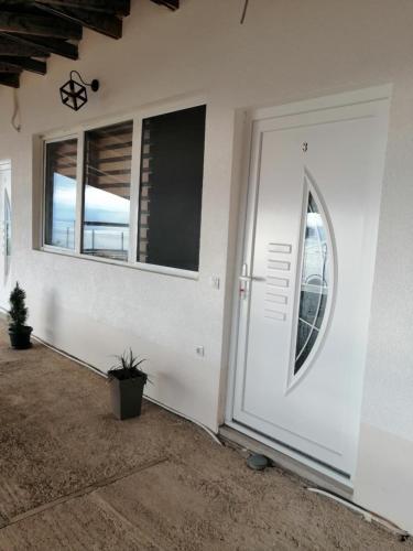 a white front door of a house with a window at CHRIS sopo in Elshani
