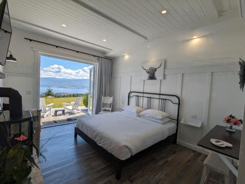 a bedroom with a bed and a large window at Autumn Lane B&B, Farmhouse Elegance & Stunning Lakeviews in West Kelowna