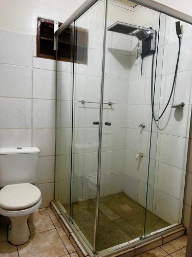 un bagno con doccia in vetro e WC di DOÑA ROSA a Puerto Iguazú