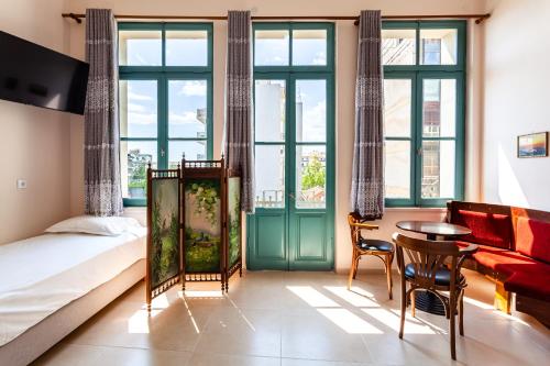 a bedroom with a bed and a table and chairs at Στούντιο Στη Στοά Βαρβουτσή#10 in Kalamata