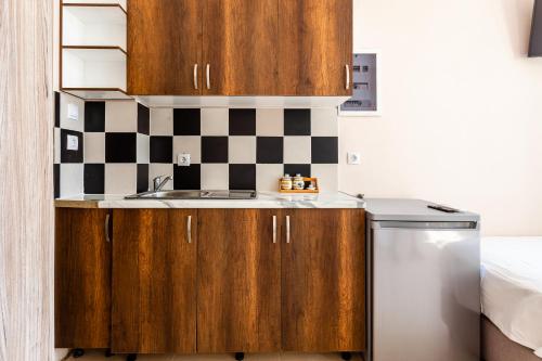 a small kitchen with wooden cabinets and a sink at Στούντιο Στη Στοά Βαρβουτσή#10 in Kalamata