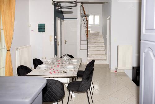 a dining room with a white table and black chairs at Beautiful village house in Metóchion