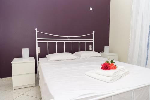 a bed with white sheets and flowers on top of it at Beautiful village house in Metóchion