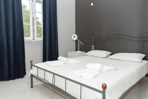 a bed with white sheets and pillows in a bedroom at Beautiful village house in Metóchion