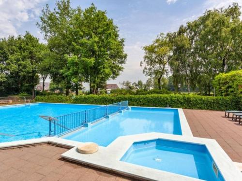 a large swimming pool in a yard with trees at Rumah Bersama Kempenbos in Diessen