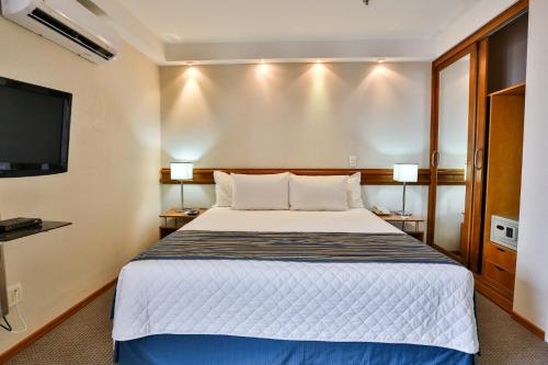 a hotel room with a bed and a flat screen tv at Transamerica Executive Sorocaba in Sorocaba