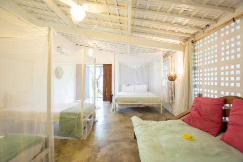 a living room with a couch and a bedroom at Villa Ostello in Paripueira