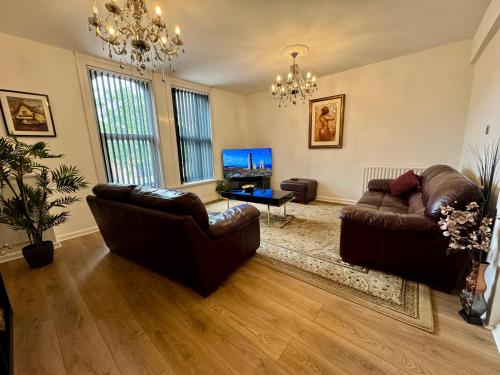 a living room with two leather couches and a tv at Lovely 2 bed Apartment, Arnold Town centre. in Nottingham