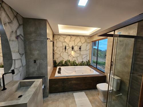 a large bathroom with a tub and a toilet at Rancho Parati in Martins