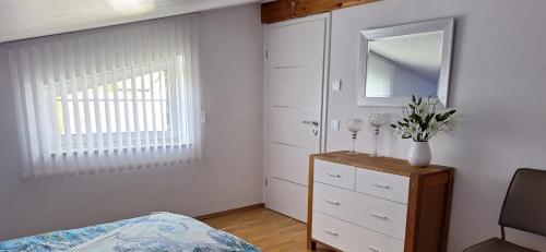 a bedroom with a bed and a dresser and a mirror at modern und gemütlich in Linden
