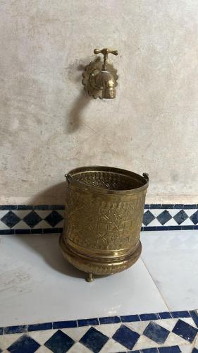 a metal bucket sitting on top of a floor at Riad Rkiya with Courtyard in Tiznit