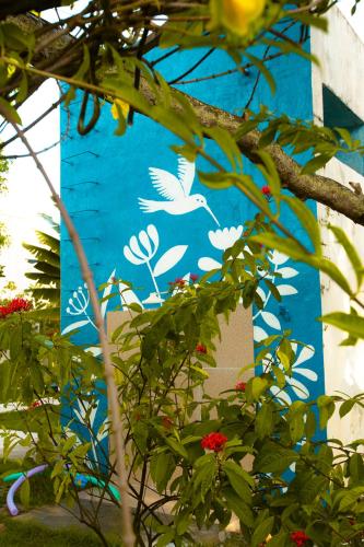 a blue building with white birds painted on it at Villa Ostello in Paripueira