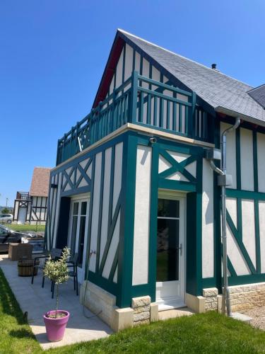 a blue and white house with a porch at Villa 11 Cyrille et Vacances in Deauville