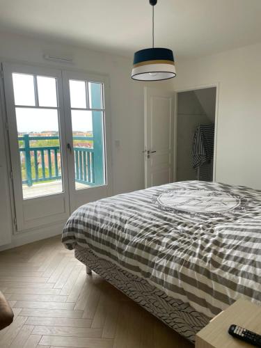 a bedroom with a bed with a checkered blanket at Villa 11 Cyrille et Vacances in Deauville