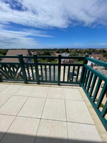 a green railing on top of a balcony with a view at Villa 11 Cyrille et Vacances in Deauville