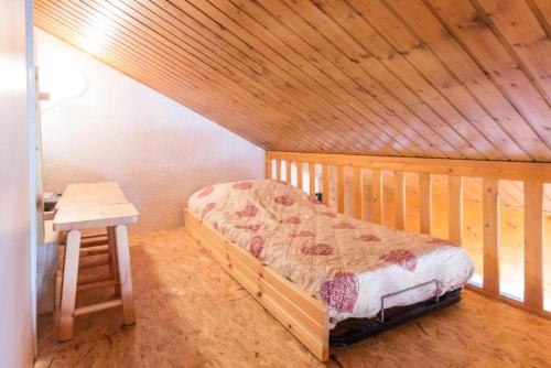 une chambre avec un lit et une table dans une pièce dans l'établissement Résidence Les Plaisances - Charmant deux pièces sous les toits MAE-4974, à Aime La Plagne
