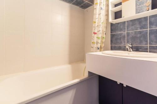 une salle de bain avec un lavabo et une baignoire et un lavabo dans l'établissement Résidence Les Plaisances - Charmant deux pièces sous les toits MAE-4974, à Aime La Plagne
