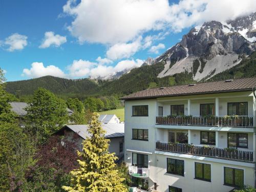 a large building with a mountain in the background at Gästehaus Herma in Ramsau am Dachstein